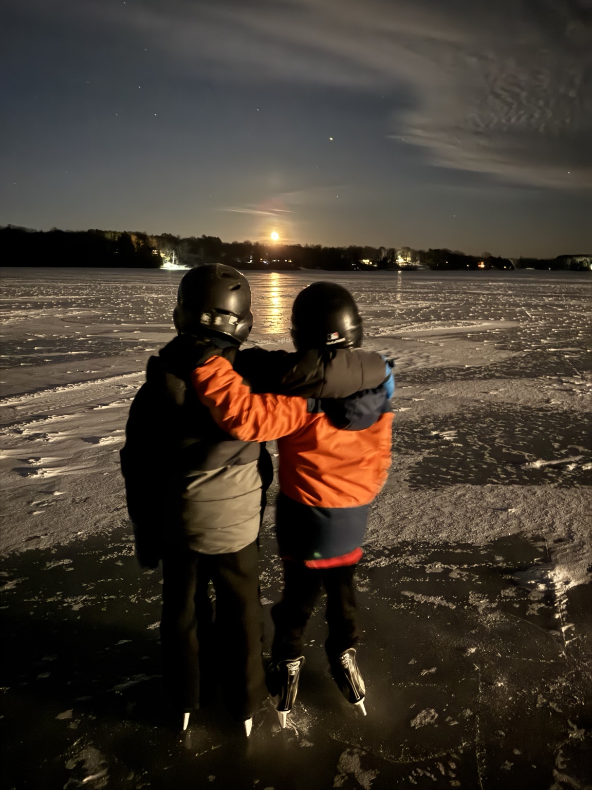 Two of Aaron's sons skating under the moon on a frozen Minnesota lake
